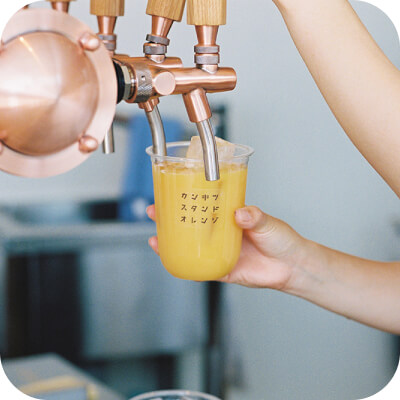 写真：オレンジジュースを注いでいます