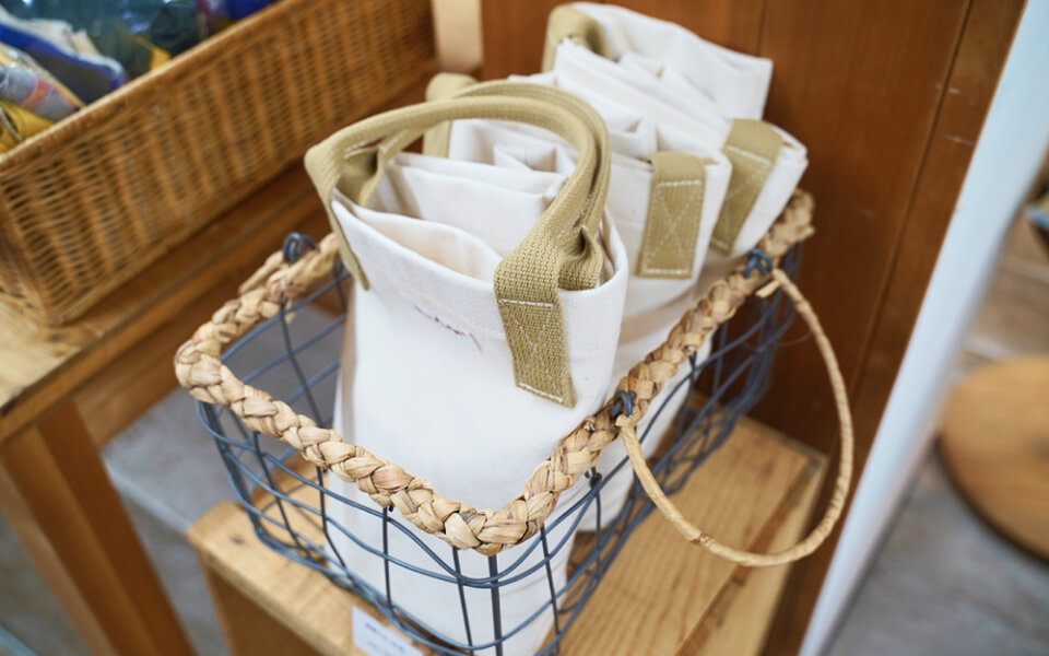 工房尾道帆布のオリジナルトートバッグがかごに並べられています