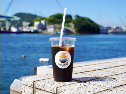 海を背景にしたアイスコーヒーの写真